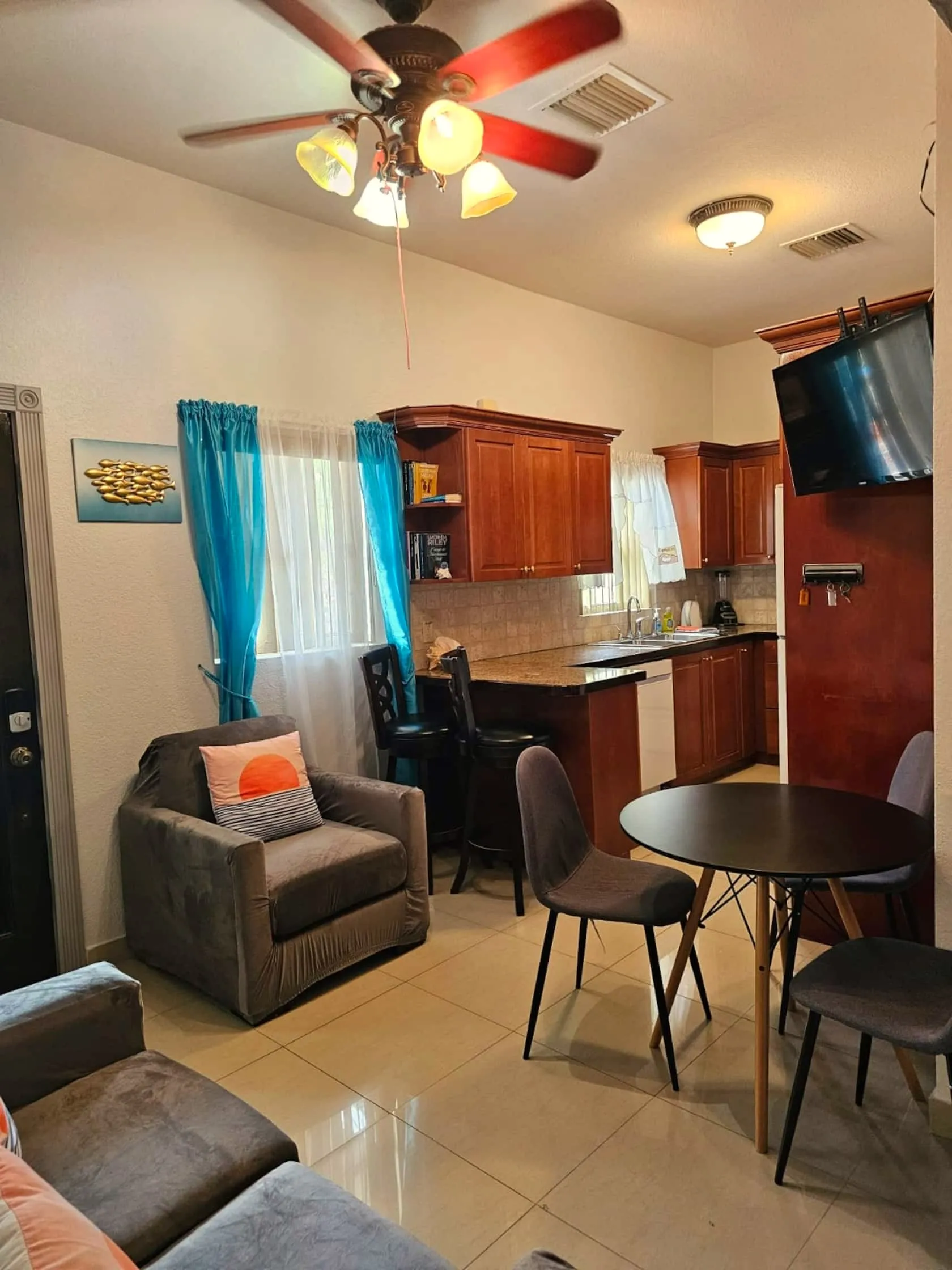 Sea Villa kitchen and dining nook with warm wood cabinetry, granite breakfast bar, and bar stools
