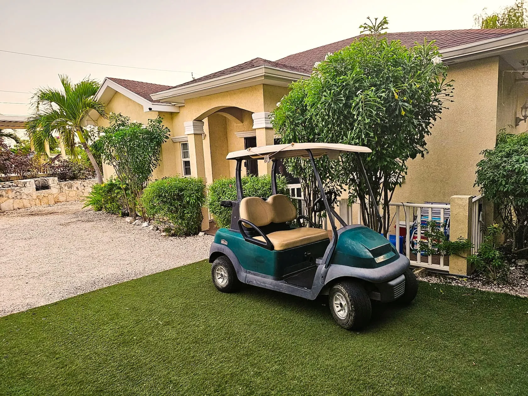 Guest golf cart parked on the lawn at the villa entrance arch