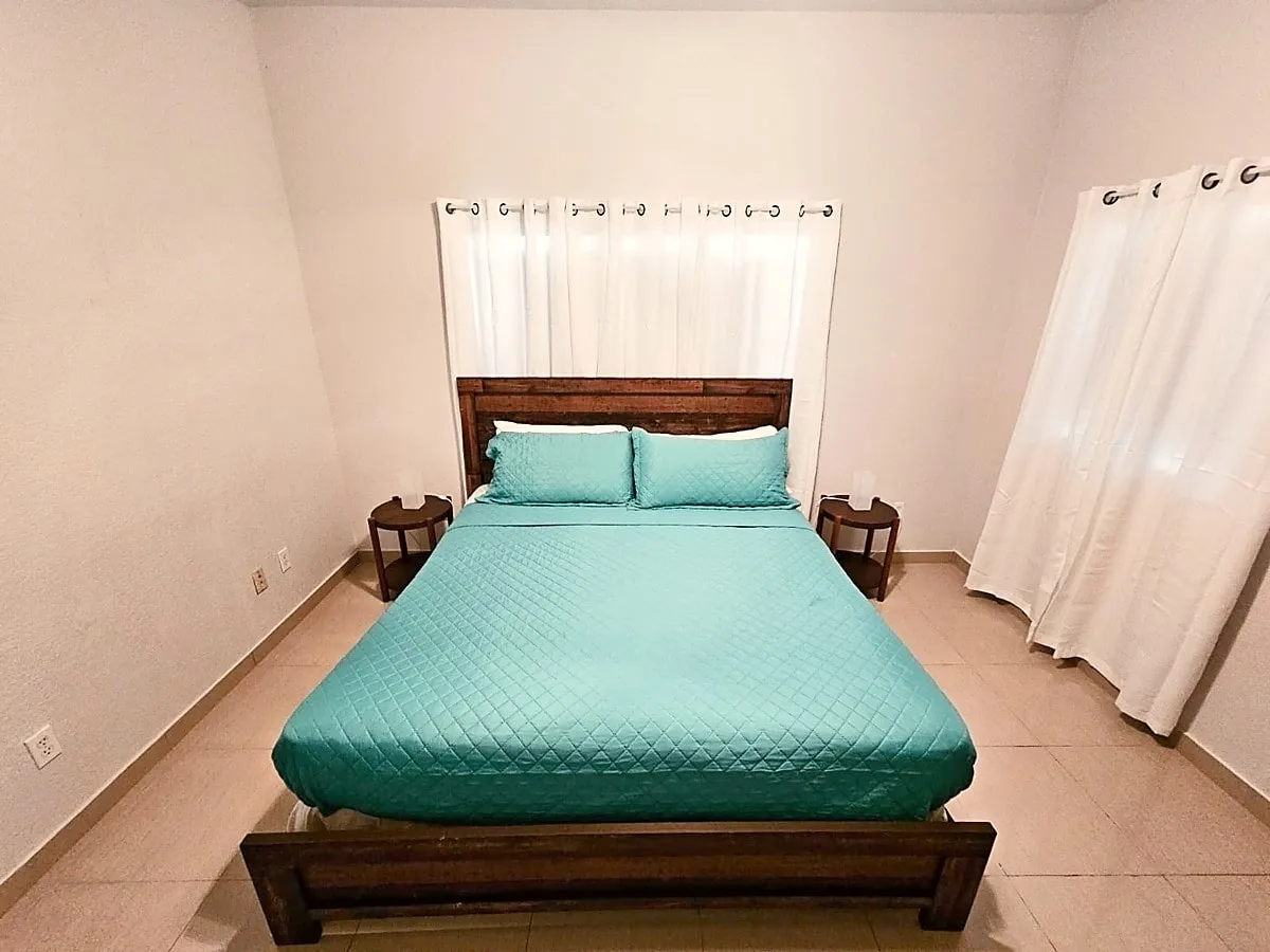 Sun Villa bedroom one with a king bed, reclaimed-wood headboard, and turquoise bedding