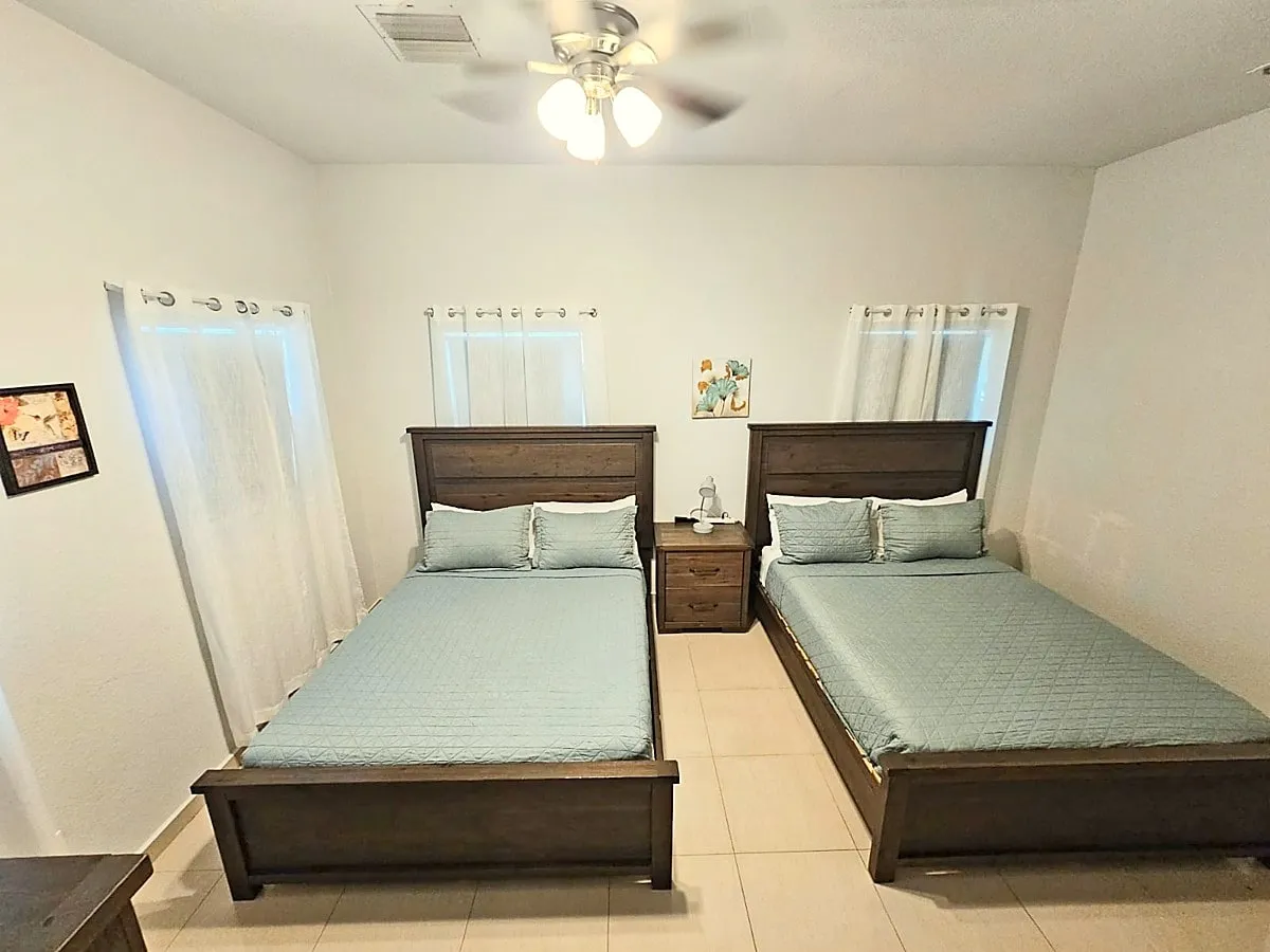 Sun Villa bedroom two with two queen beds in seafoam quilts and a shared nightstand